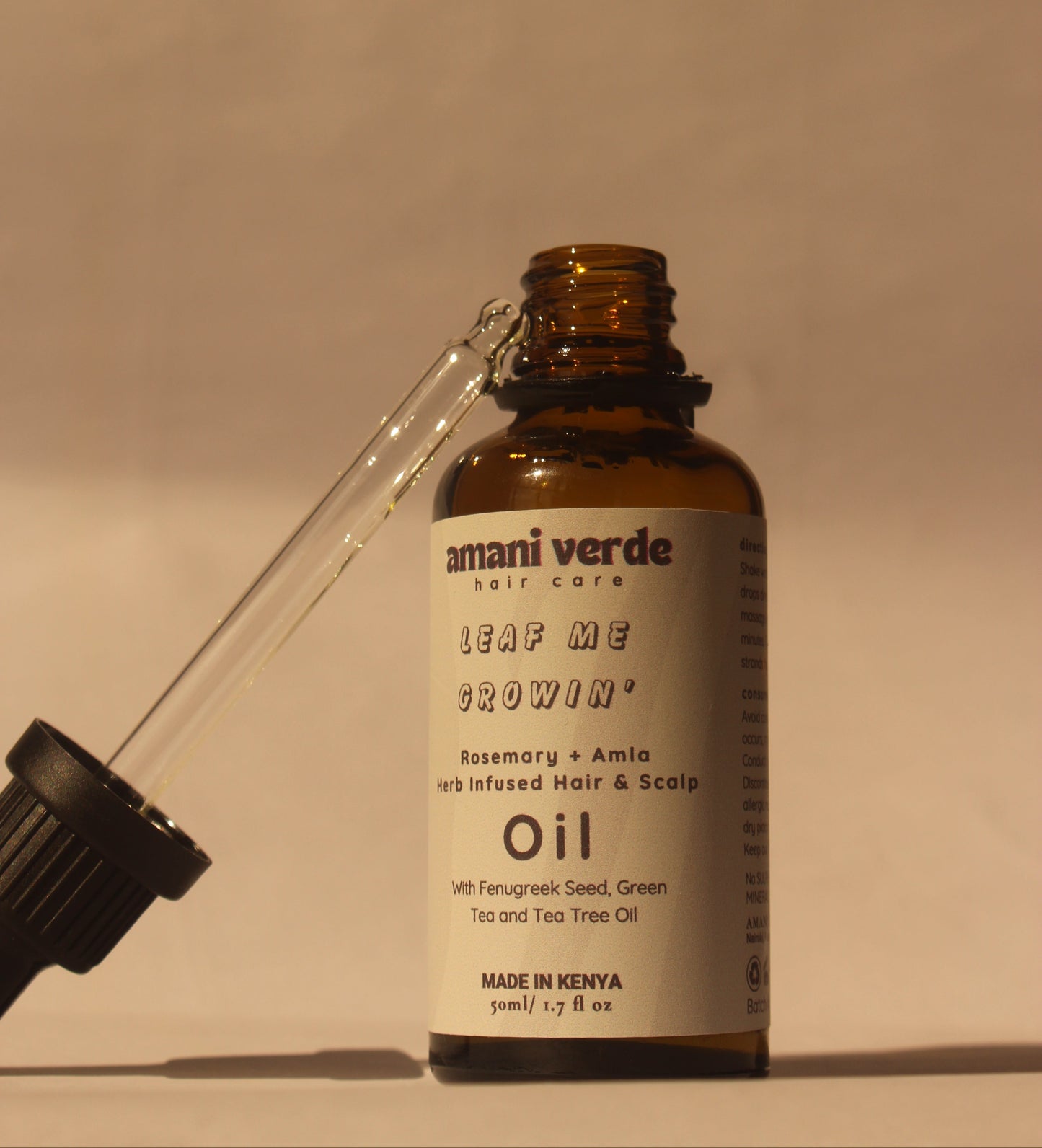 Bottle of Amani Verde oil with dropper on a white background