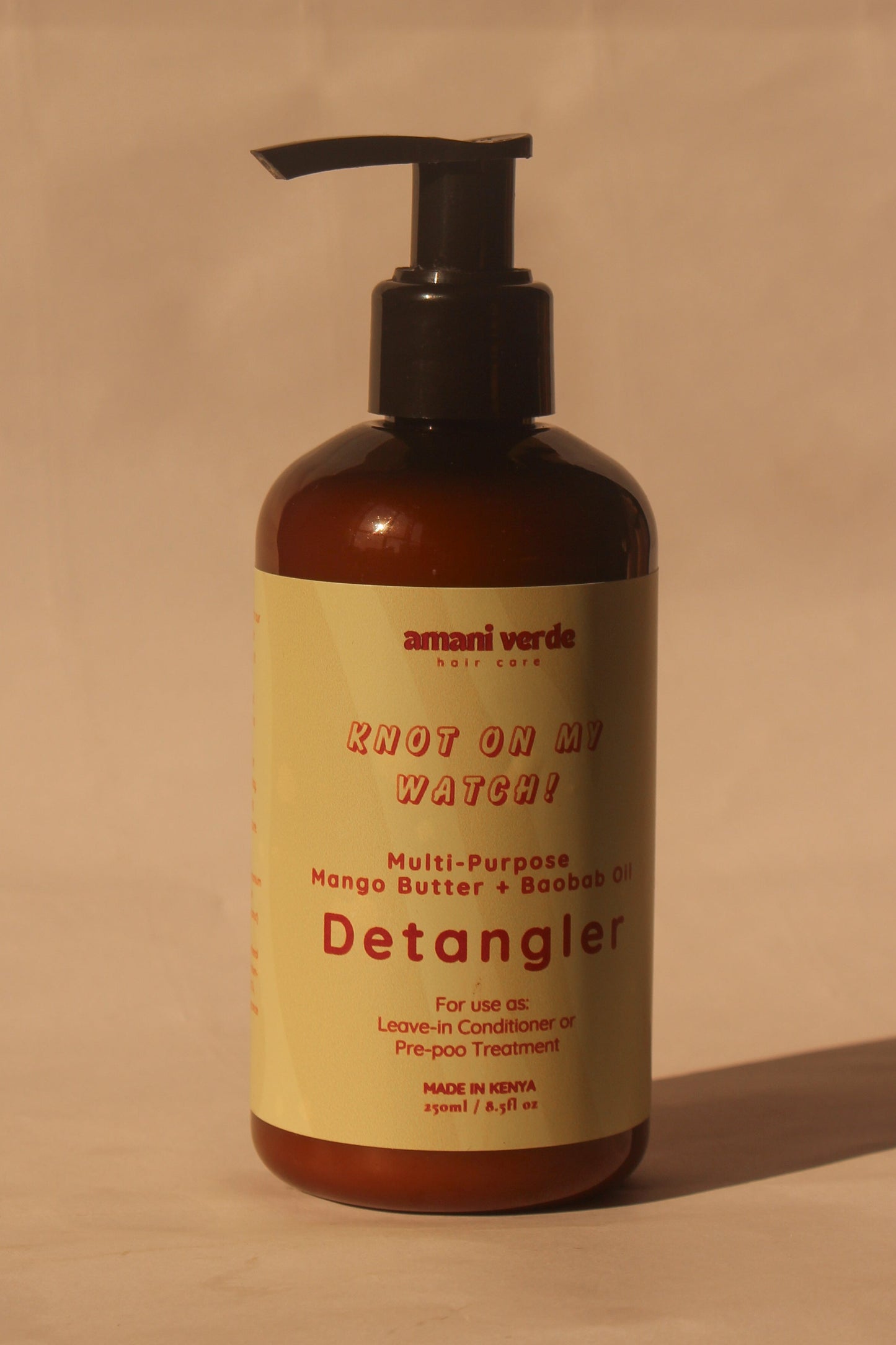 Detangler bottle with pump on a beige background
