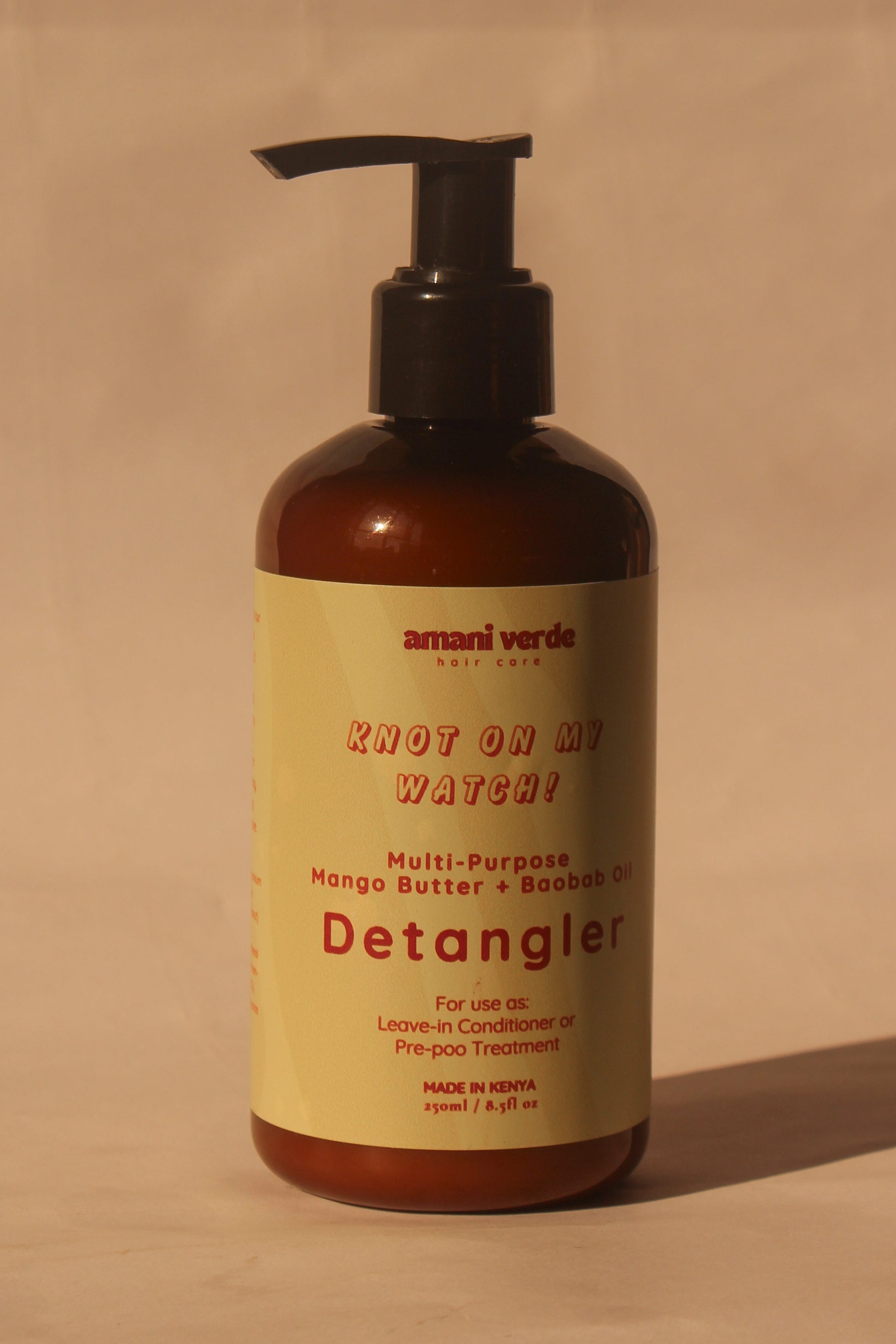 Detangler bottle with pump on a beige background